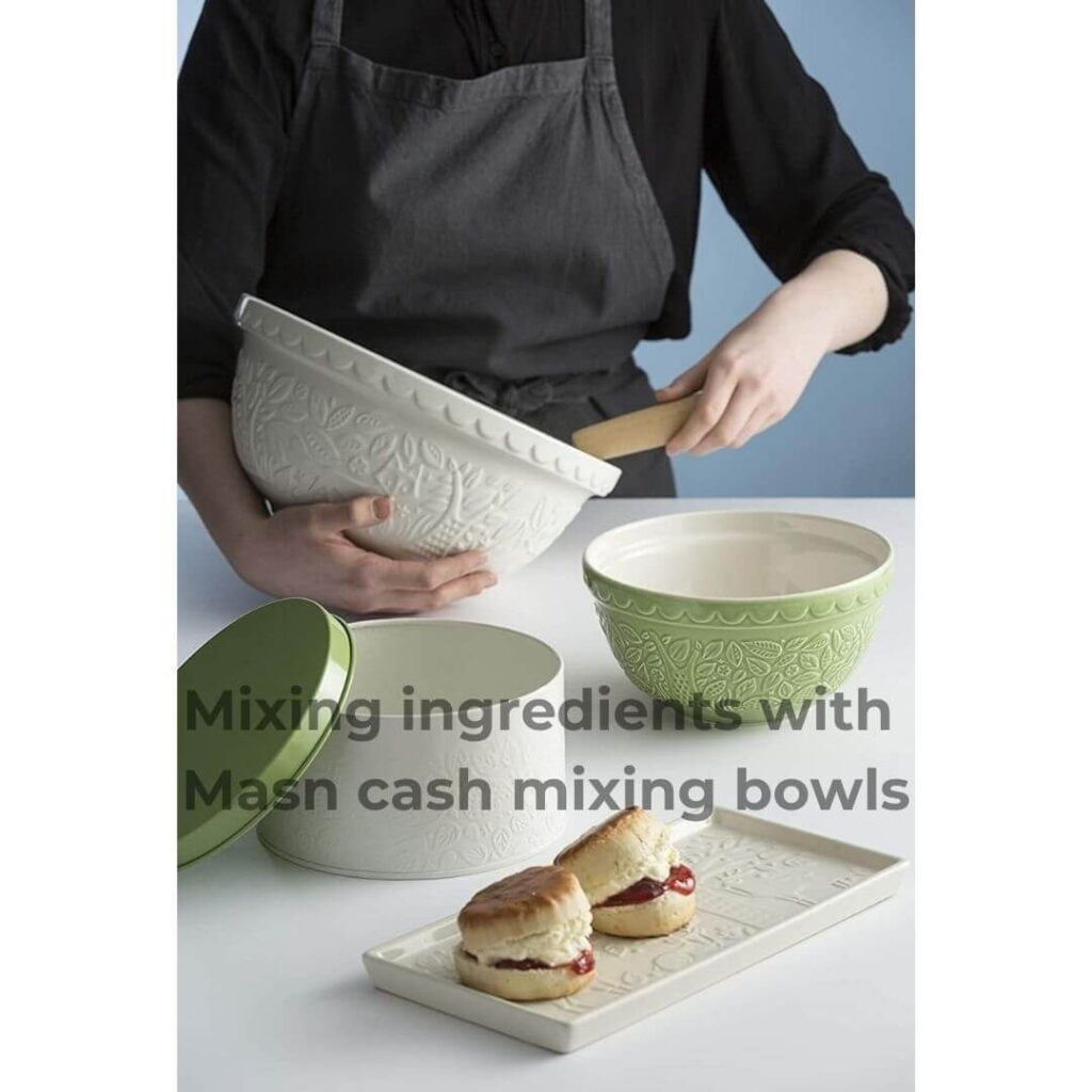 Person mixing ingredients in a Mason Cash mixing bowl on a kitchen counter