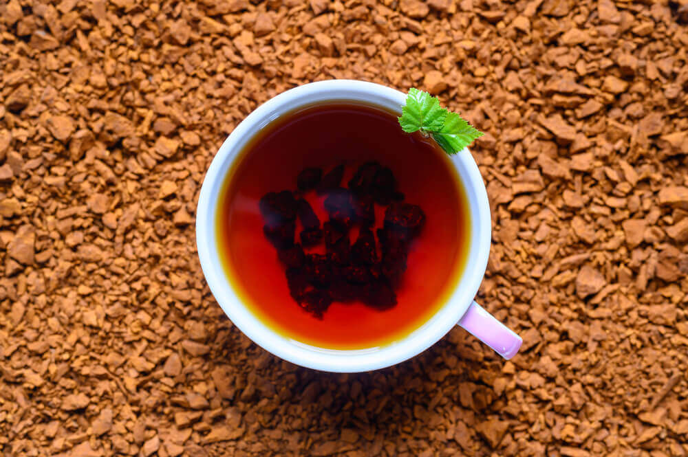 
A steaming cup of classic mushroom tea with  mint leaves
