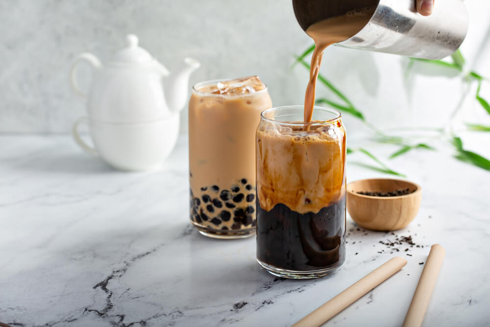 Step-by-step guide on how to make boba protein tea, including preparation of boba pearls and mixing with protein powder.